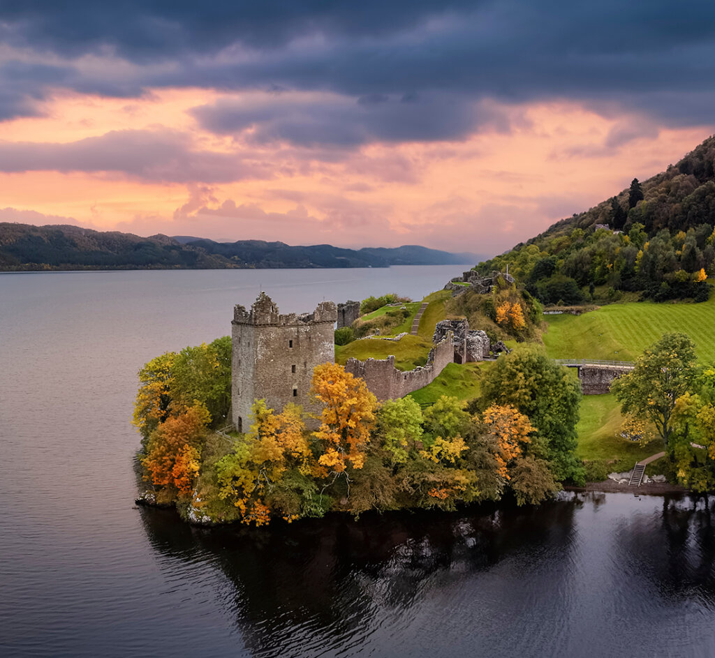 Aerial view of the impressive Urquhart Castle at the Loch Ness during autumn sunset time